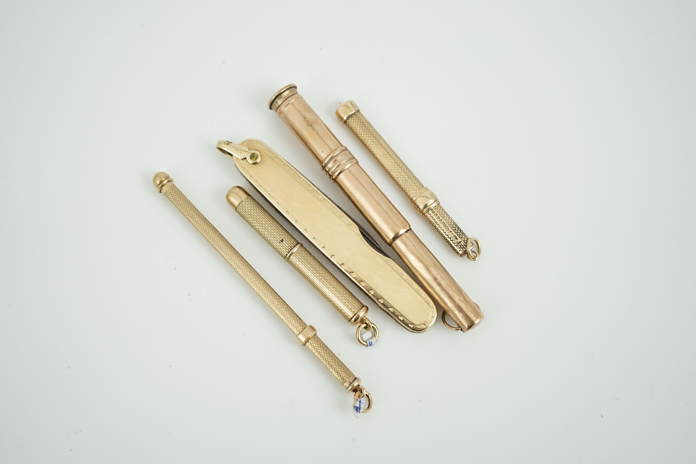 A 9ct mounted cigar piercer, 77mm, a 9ct gold mounted swizzle stick, a yellow metal mounted toothpick, a similar toothpick by S. Mordan & Co and a yellow metal mounted pen knife.